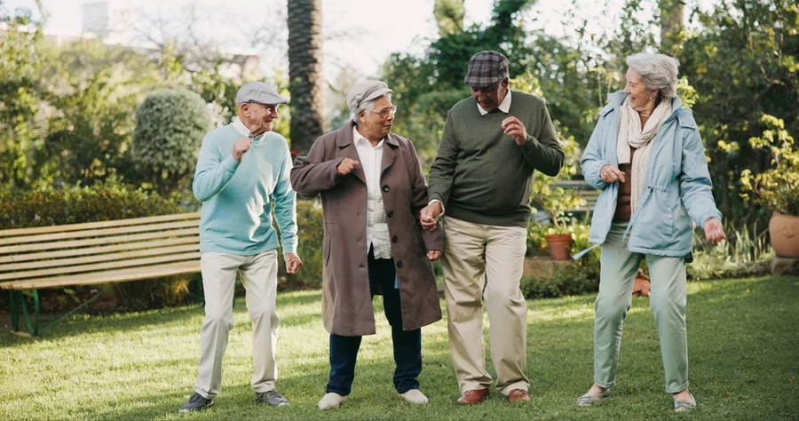 Senior people, dancing and bonding in retirement home